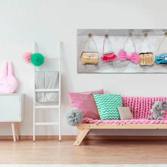 Quadro com pequenas bolsas penduradas sobre sofá juvenil cor-de-rosa
