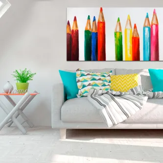 Quadro com lápis de cor coloridos alinhados acima de sofá com almofadas
