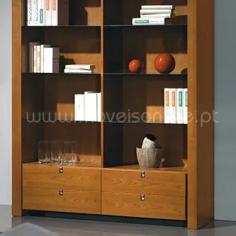 Livreiro Stilus em madeira com prateleiras e gavetas, livros e objetos decorativos.