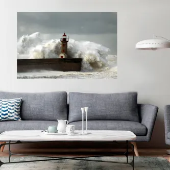 Farol sobre quebra-mar com ondas gigantes a rebentar sob céu nublado