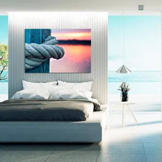 Quadro amarre com corda presa a pilar e pôr do sol junto ao mar
