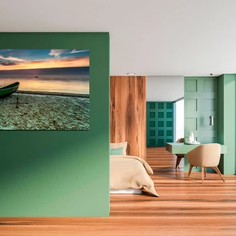 Quadro com barco na praia ao pôr do sol, pendurado numa parede verde de quarto moderno