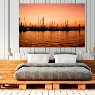 Quadro bucólico de veleiros em silhueta ao pôr do sol com reflexos na água