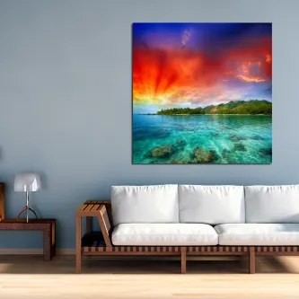 Quadro fenómeno colorido com mar cristalino, ilhéu verde e céu dramático ao pôr do sol