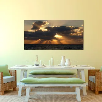 Quadro com nuvens densas e raios de sol sobre o mar, pendurado sobre mesa de jantar
