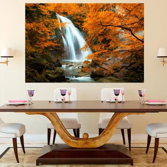 Quadro com cascata entre vegetação outonal laranja sobre parede acima de mesa de jantar