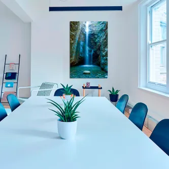 Quadro 'Alta Cascata' com imagem de cascata luminosa numa sala de reuniões