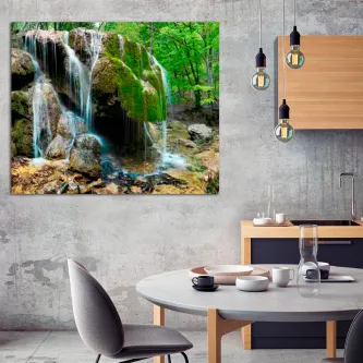 Cachoeira com finos fios de água em bosque verde sobre rochas