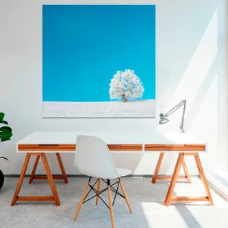 Quadro Arbol Nevado com árvore nevada sobre fundo azul, pendurado acima de secretária