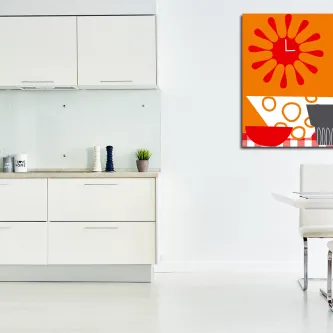 Quadro relógio laranja com flor estilizada pendurado numa cozinha branca