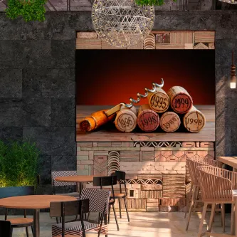 Quadro com rolhas de cortiça empilhadas e saca de rolhas sobre fundo vermelho