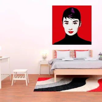 Quadro Audrey pop art com retrato feminino estilizado em fundo vermelho acima de cama
