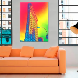 Quadro do edifício Flatiron em cores pop vibrantes sobre parede acima de sofá laranja.