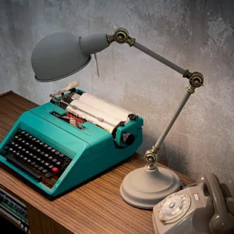 Candeeiro de secretária Truman cinzento articulado sobre mesa com máquina de escrever turquesa