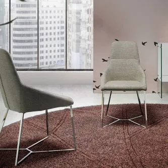Cadeira swivel estofada cinzenta com base metálica sobre tapete, junto a janela
