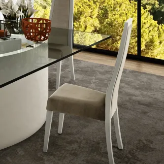 Cadeira Elite branca com assento bege e encosto alto junto de mesa de vidro