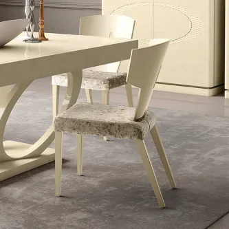 Cadeira Eclipse creme com assento estofado padrão marmoreado junto a mesa de jantar