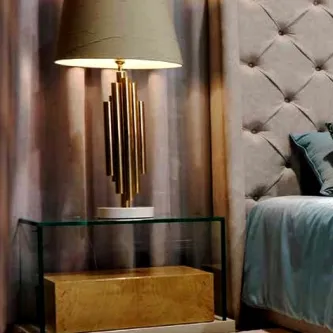 Mesa de cabeceira Alfaiate Clear em vidro com candeeiro dourado e cabeceira capitoné