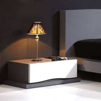 Mesa de cabeceira Manhattan branca e preta com candeeiro e livros ao lado da cama