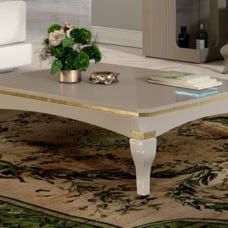 Mesa de centro Ella bege com detalhes dourados, pernas torneadas e arranjo de flores