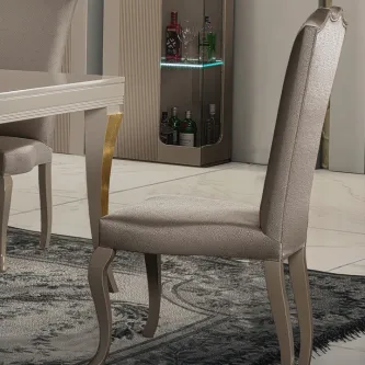 Cadeira Hanna estofada bege com encosto alto e pernas curvas prateadas