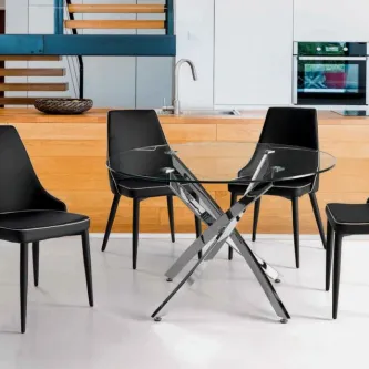 Mesa de vidro redonda com base metálica cruzada e quatro cadeiras pretas