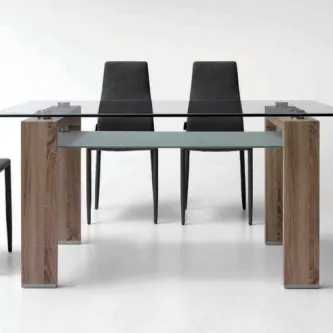 Mesa de vidro Willy com tampo transparente, pés de madeira e cadeiras pretas.