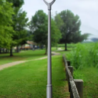 Candeeiro de pé Fuma Big cinzento junto a caminho em parque com relvado