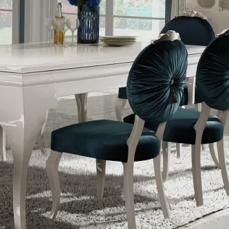 Cadeira Nila em veludo azul-petróleo com encosto redondo franzido e pernas brancas