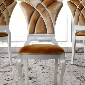 Cadeira Khyara com estofado dourado e estrutura branca entalhada