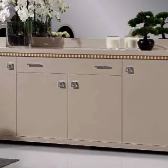 Aparador Império creme com três portas, friso dourado e plantas decorativas