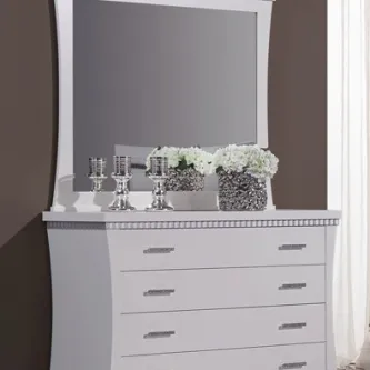 Cómoda branca com quatro gavetas, espelho curvo e objetos decorativos prateados