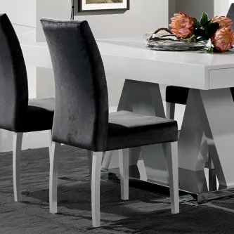 Cadeira Blanco estofada cinzento escuro com pernas brancas junto a mesa de jantar