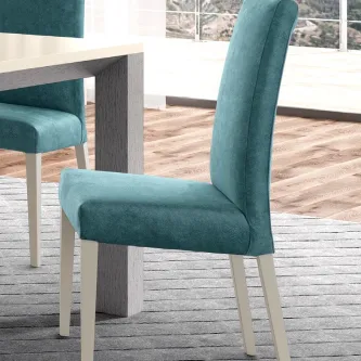 Cadeira Espiga estofada azul-turquesa com pernas brancas junto a mesa de jantar