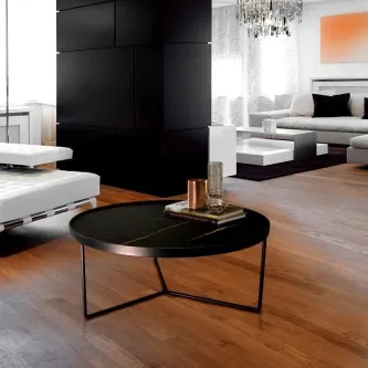 Mesa de centro Paola redonda preta com tampo liso e base metálica em sala moderna