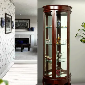 Vitrine redonda em madeira com portas de vidro, prateleiras e objetos decorativos