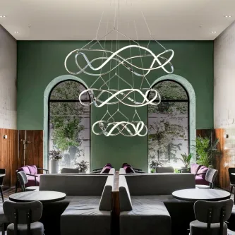 Candeeiro de teto Molly 3A com anéis LED entrelaçados numa sala lounge moderna