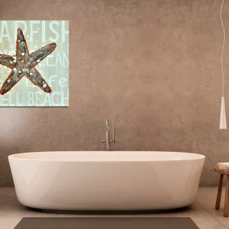 Quadro estrela-do-mar acima de banheira branca numa casa de banho moderna