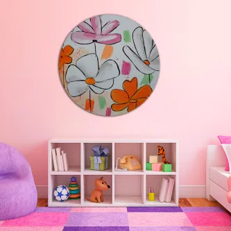 Quadro redondo com flores coloridas pendurado numa parede rosa acima de estante de brinquedos