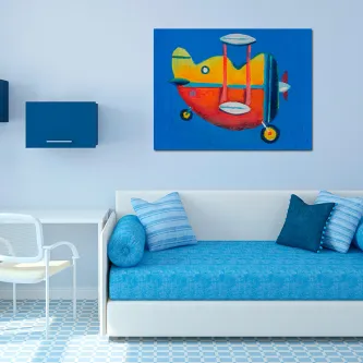 Quadro de avião colorido pendurado acima de sofá azul