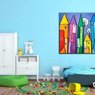 Quarto infantil com quadro de torres coloridas sobre cama azul e brinquedos no chão