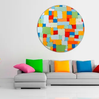 Pintura abstrata colorida redonda na parede acima de sofá com almofadas multicolores