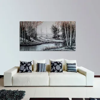 Quadro de paisagem em tons de cinza com árvores, riacho e barcos, suspenso sobre sofá branco