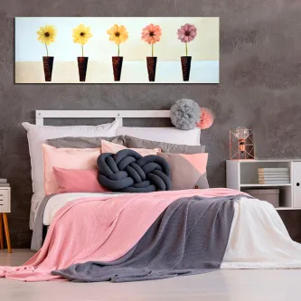 Pintura de cinco flores em vasos sobre cabeceira de cama com roupa rosa e cinzenta