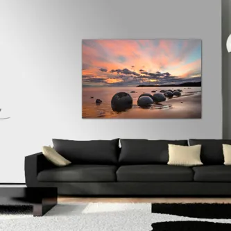 Quadro de pedras esféricas numa praia ao pôr do sol