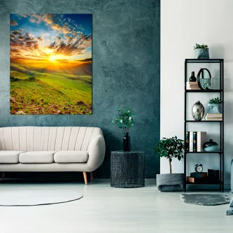 Pintura de prados com colinas verdes e pôr do sol dramático pendurada numa sala