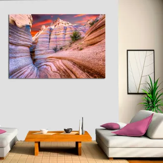 Pintura de montanhas rochosas com camadas de rocha colorida e céu alaranjado