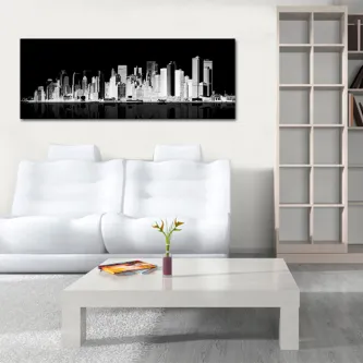 Pintura moderna da cidade em tons de preto e branco sobre sofá branco numa sala minimalista