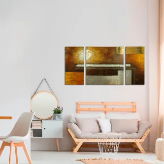 Tríptico abstrato em tons dourados e brancos sobre sofá numa sala minimalista