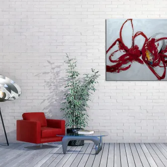 Pintura abstrata com traços vermelhos pendurada numa parede branca